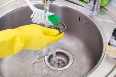 Woman cleaning kitchen sink clipart