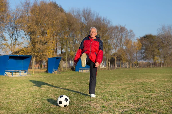 Старик играет в футбол — стоковое фото