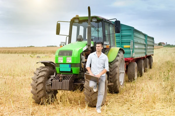 Affärsman med laptop och traktor — Stockfoto