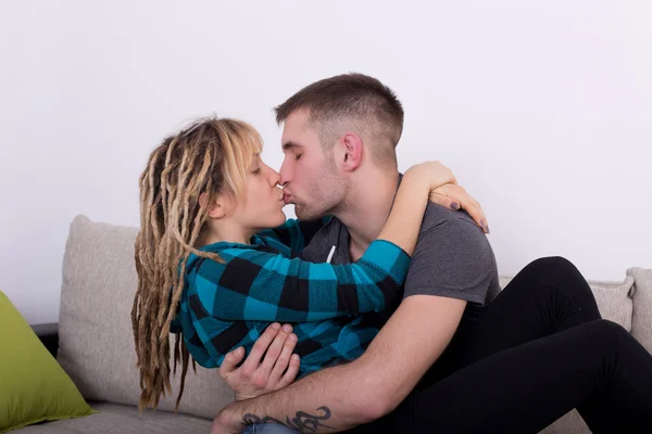 Junges Paar küsst sich auf Sofa — Stockfoto