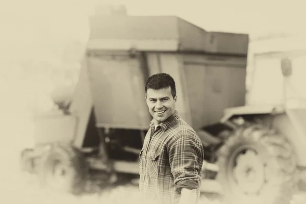 Sepia image of farmer with harvester — Stock Photo, Image