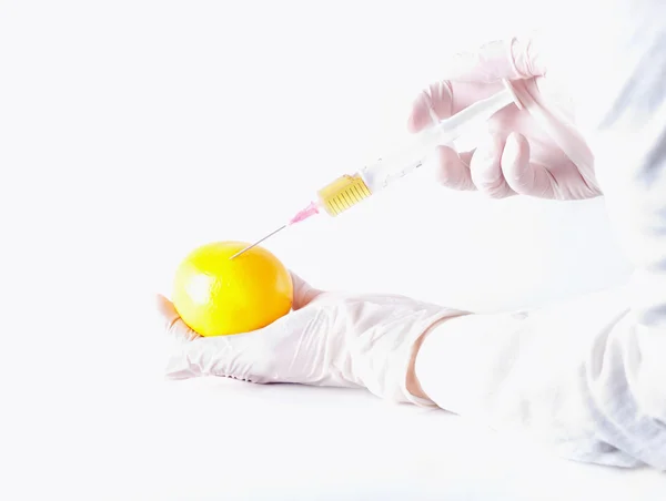 Científico aplicando la inyección a la fruta —  Fotos de Stock