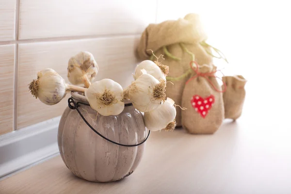 Knoblauch im Topf und Säcke auf der Arbeitsplatte — Stockfoto