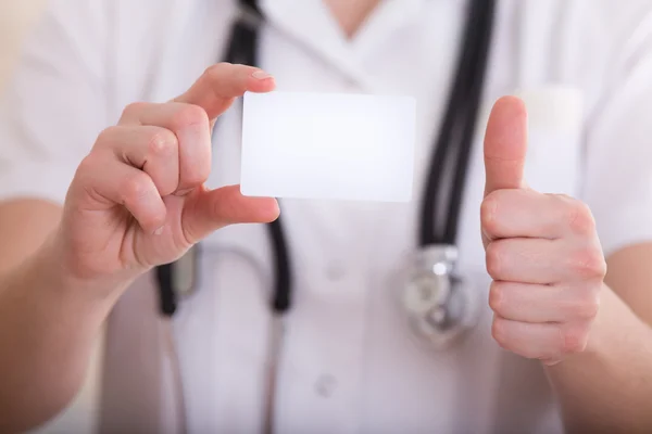 비즈니스 카드와 엄지손가락 보여주는 여성 의사가 — 스톡 사진