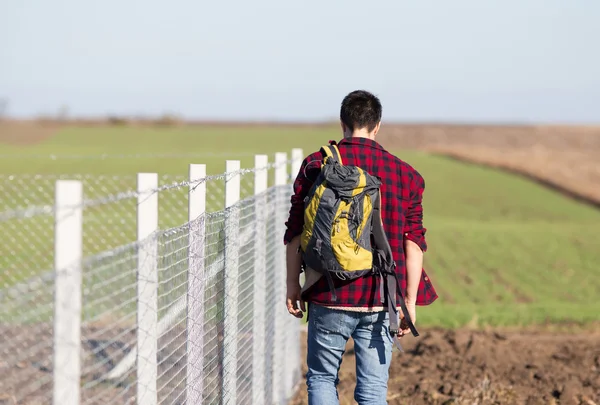 Man met rug naast draad hek — Stockfoto