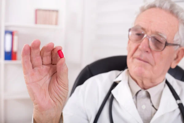 Läkare visar röd tablett — Stockfoto