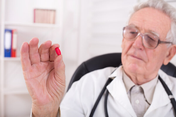 Doctor showing red tablet