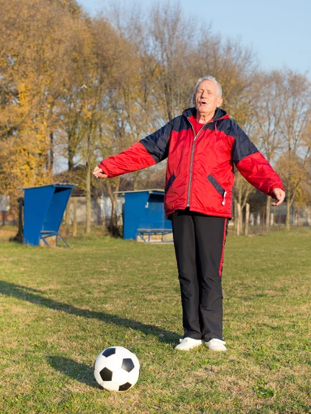 Старший чоловік грає у футбол — стокове фото