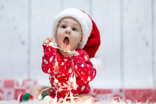 Kleines Weihnachtsbaby mit Lichtern lizenzfreie Stockbilder