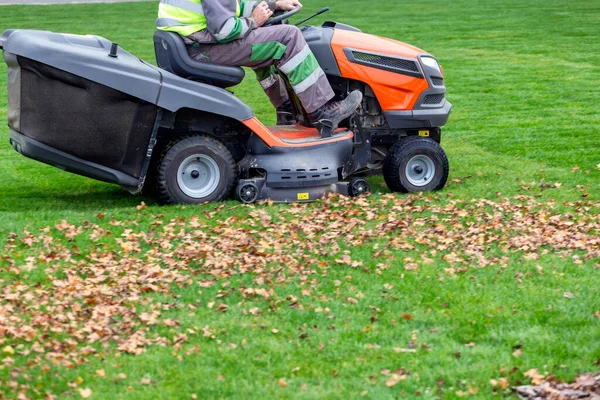 Tractor mower in motion, cutting the lawn. Cutting the grass in a park.