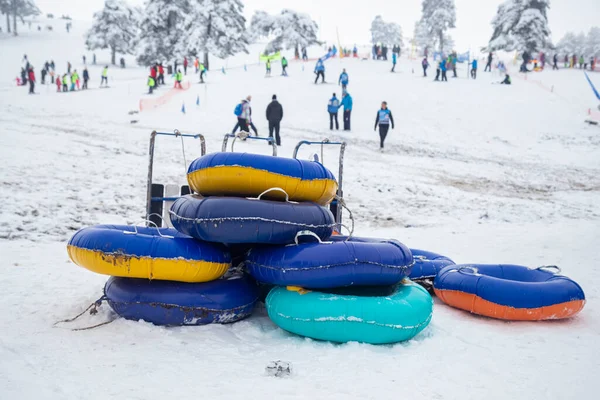 冬に遊ぶ子供たちのためのカラフルな雪のそりチューブ 雪の丘 屋外の楽しさと活動から乗る — ストック写真