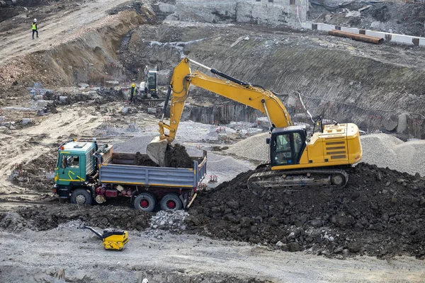 ダンプトラック 建設現場の土工に砂をロード掘ります 重いダンプトラックをロードする掘削機 — ストック写真