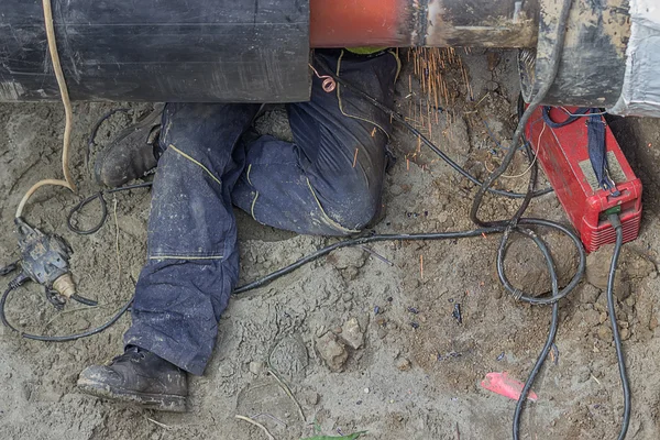 Welder worker grinding the weld in trench under pipeline 2 — Stock Photo, Image