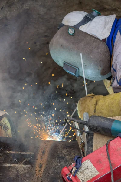 Welder welding heat pipes in trench 3 — Stock Photo, Image