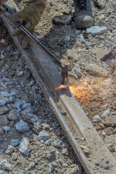 Welder using oxyacetylene cutting torch to cut old tram tracks — Stock Photo, Image