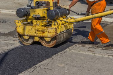 City crew installing asphalt speed bump clipart