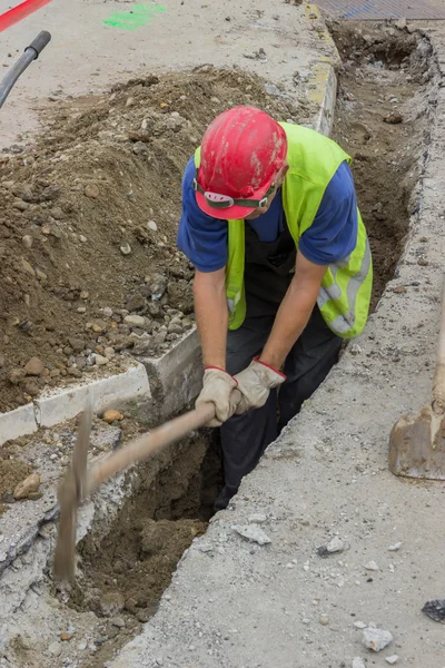 Use pickaxe to dig trench — Stock Photo, Image