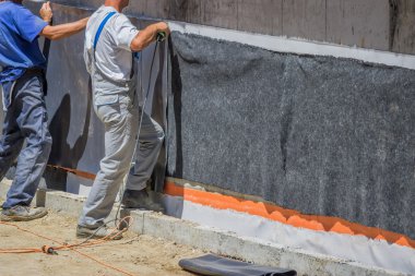 Workers installing wall insulation 2 clipart