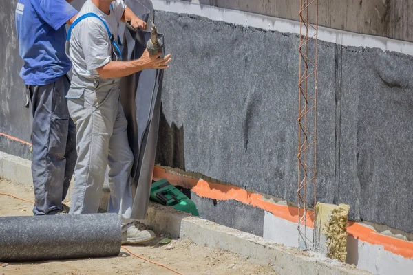 Trabajadores instalando aislamiento mural — Foto de Stock