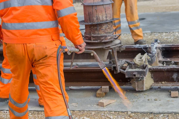 Lavoratori in arancione che utilizzano un bruciatore a gas ad ossicombustibile — Foto Stock