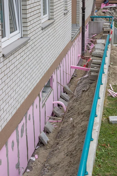 Trenching around building for new layer of foam insulation — Stock Photo, Image