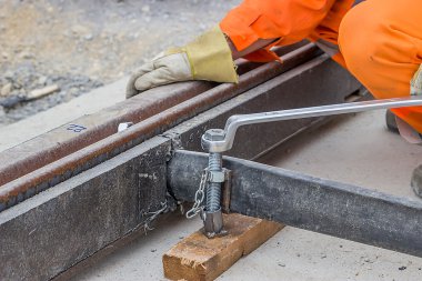 Rail worker tightening a bolt using wrench 2 clipart