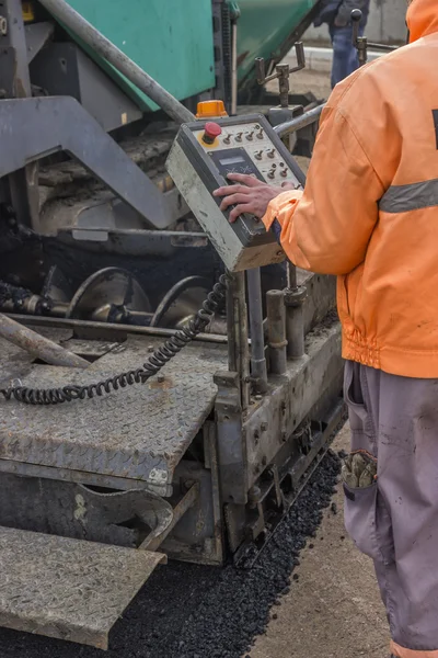 Asphalt worker hand controling paver machine — Stock Photo, Image
