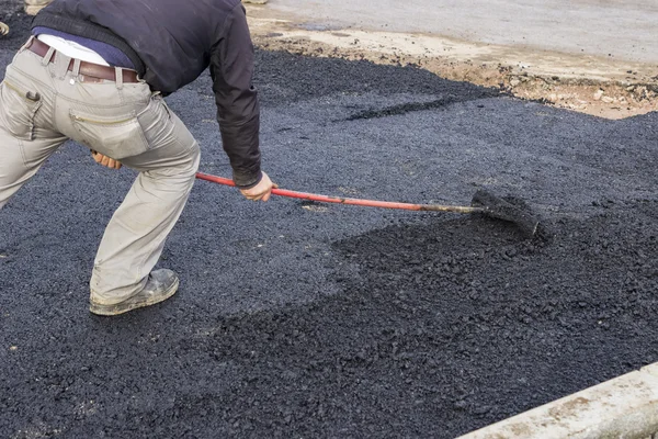 Travailleur utilisant un râteau pour niveler la chaussée asphaltée 4 — Photo