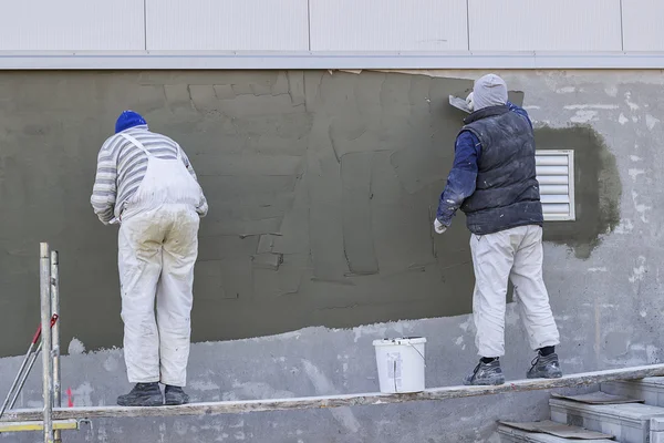 Trabajadores enyesando una pared al aire libre — Foto de Stock