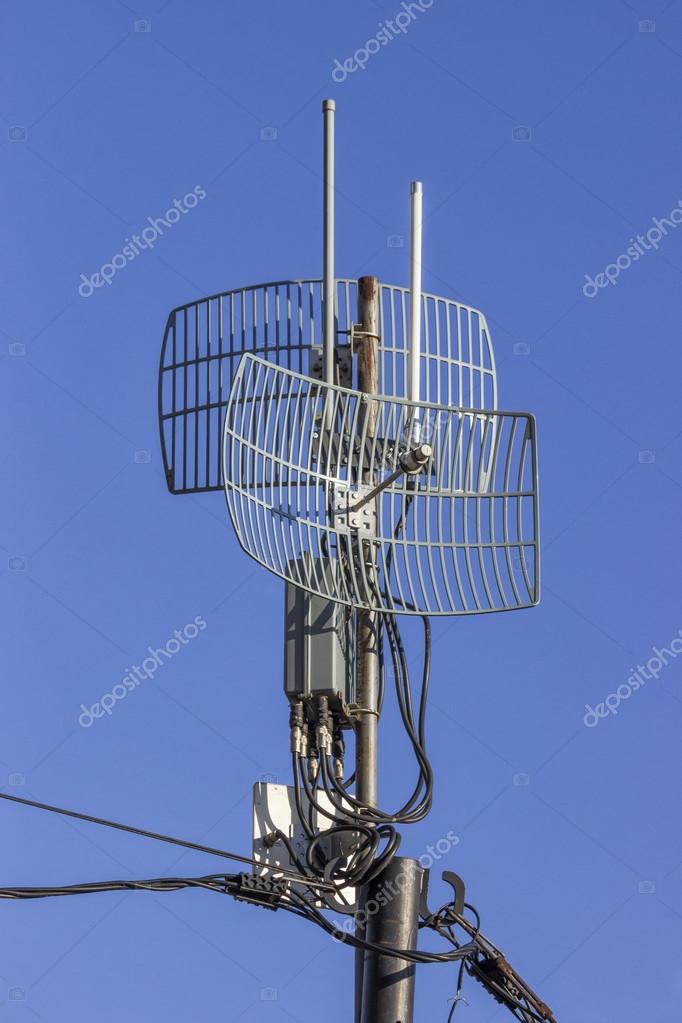 Outdoor wireless parabolic directional antennas on pole Stock Photo by
