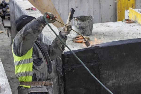 Insulation worker melting bitumen felt — Stock Photo, Image
