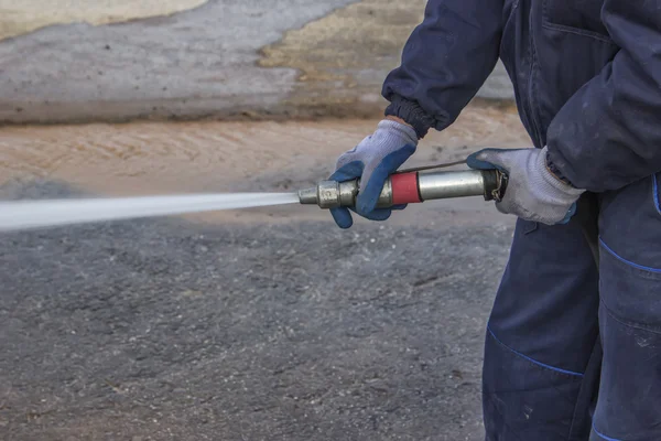 Using water hose to clean road 2 — Stock Photo, Image