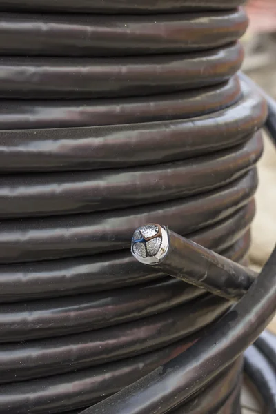 Czarny przemysłowych podziemny kabel elektryczny na duży drewniany kołowrotek — Zdjęcie stockowe