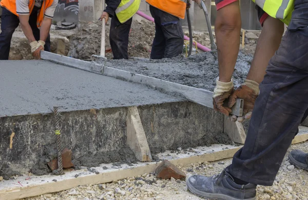 Stavitelé úroveň mokrý beton s kovovou potěru — Stock fotografie