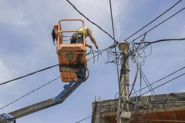 Trabajador de postes de servicios públicos reemplazando cables en un poste eléctrico — Foto de Stock