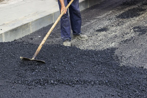 Mano de trabajador con rastrillo de asfalto — Foto de Stock