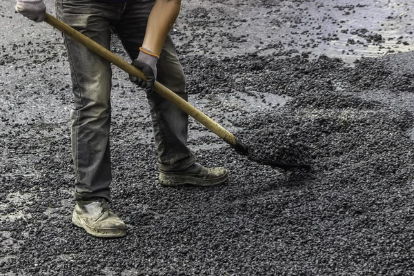 Pavement worker spread asphalt with shovel — Stock Photo, Image