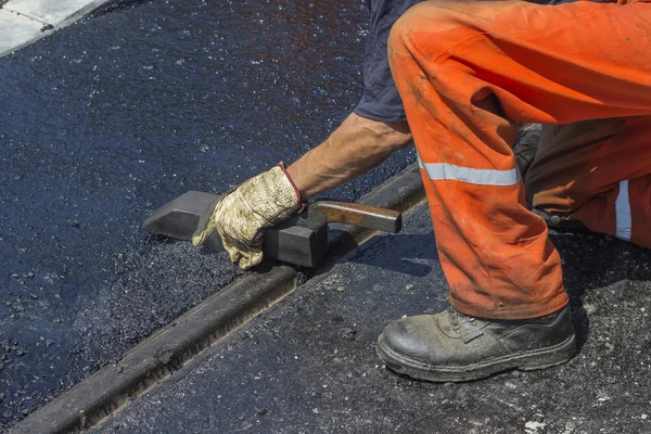 Travailleur utilisant un outil spécial pour répandre l'asphalte de mastic 2 — Photo