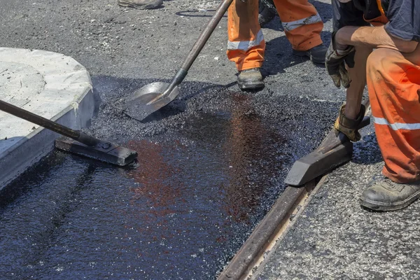 Trabajadores que utilizan una herramienta de asfalto para extender el asfalto masivo 2 —  Fotos de Stock