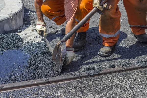 Travailleurs utilisant une pelle pour répandre de l'asphalte au mastic — Photo