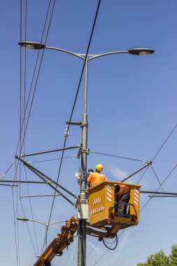 Lineworkers work on overhead power line clipart
