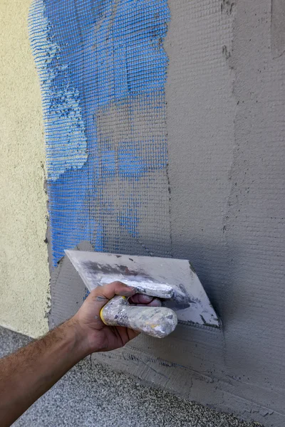 Spreading mortar on mesh of styrofoam insulation wall — Stock Photo, Image