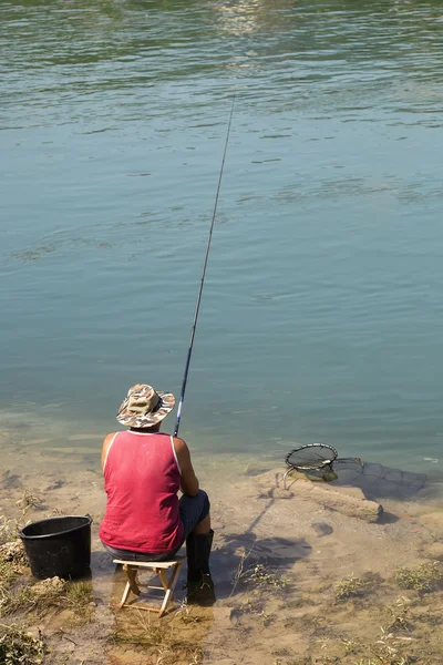 坐在一把椅子在河上的渔夫 — 图库照片