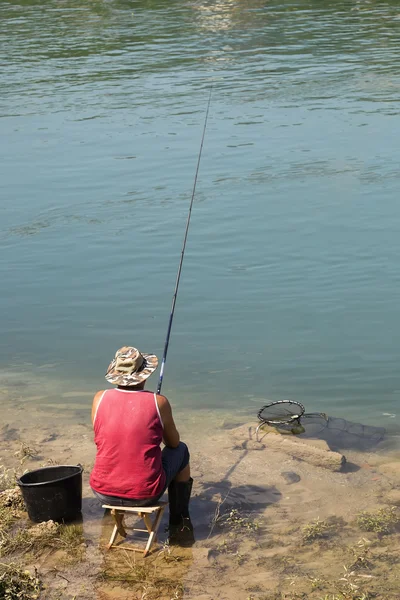 Fischer sitzt auf einem Stuhl im Fluss — Stockfoto