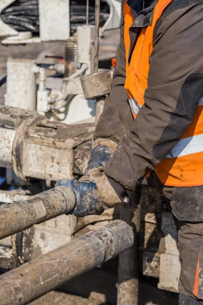 Drilling crewmen hands connect drill pipe — Stock Photo, Image