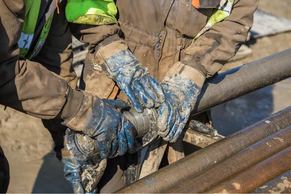 Robotnik ręce sprawdza podstawowe diamentowe wiertło — Zdjęcie stockowe