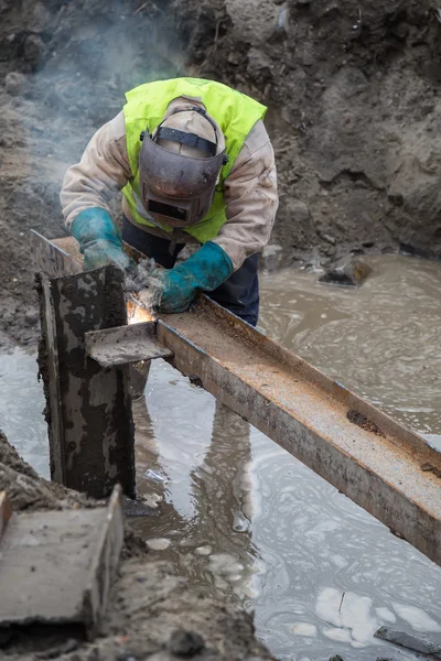 Welder with protective equipment welding steel beams — Stock Photo, Image