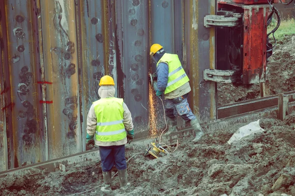 Lavoratore con dispositivo di protezione travi in acciaio molatura 2 — Foto Stock