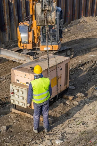 Lavoratori che installano un generatore elettrico nel cantiere 3 — Foto Stock