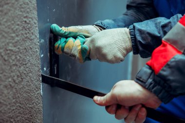 Hırsızlar ön metal kapıyı levye ve yankesicilerle kırıyorlar. Doğaçlama aletler. Eller yakın plan..